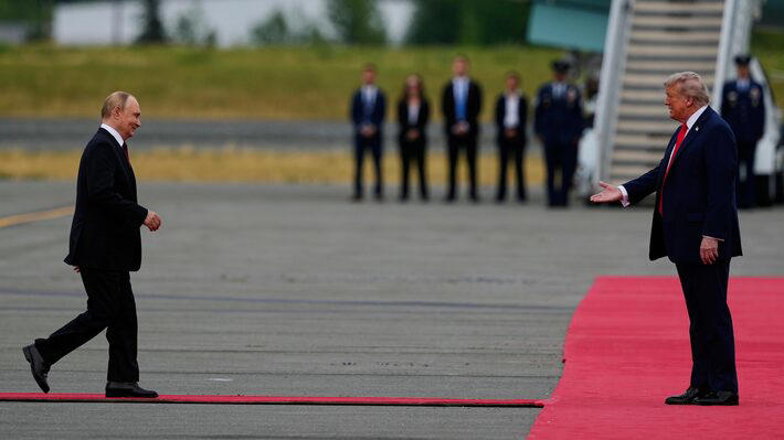 Vladimir Putin e Donald Trump se cumprimentam para as câmeras antes do início da reunião.